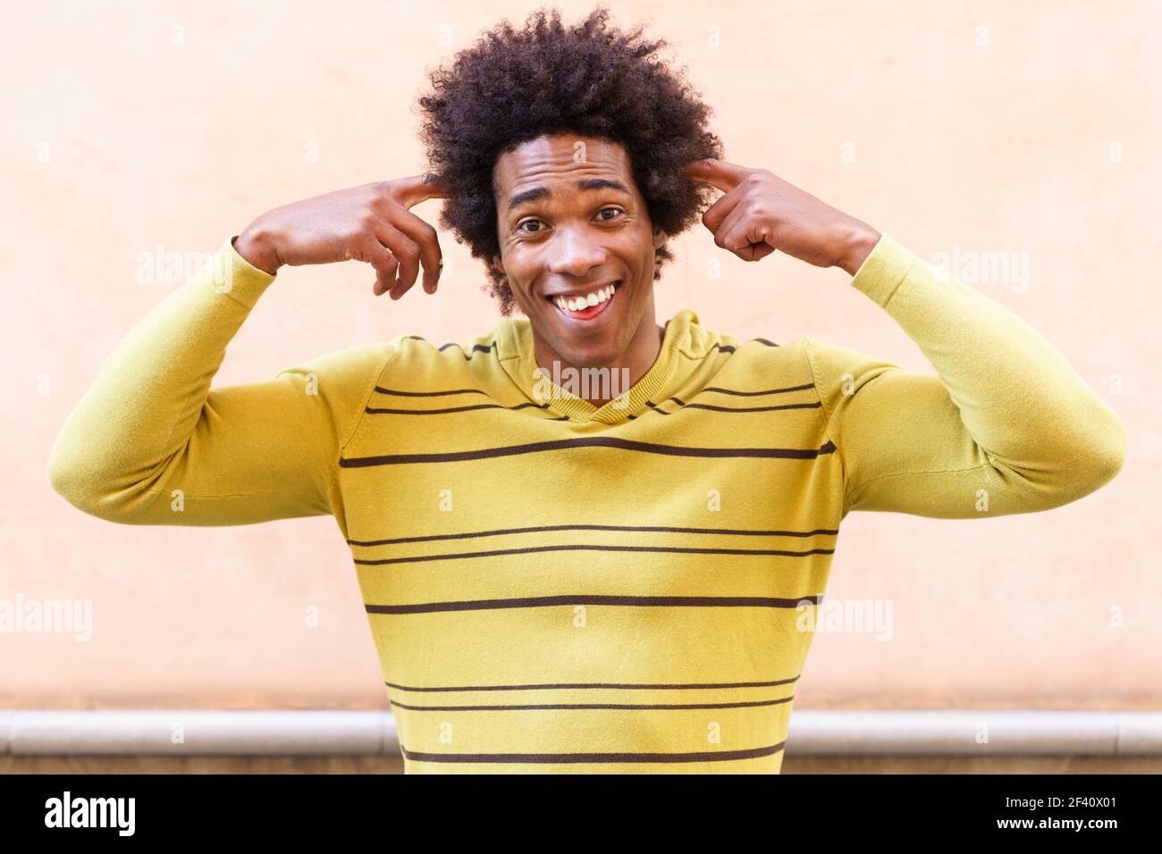 Schwarzer Mann mit afro Haar Putting einen verrückten Ausdruck im Freien. Schwarzer Mann mit afro Haar setzen einen verrückten Ausdruck Stockfoto