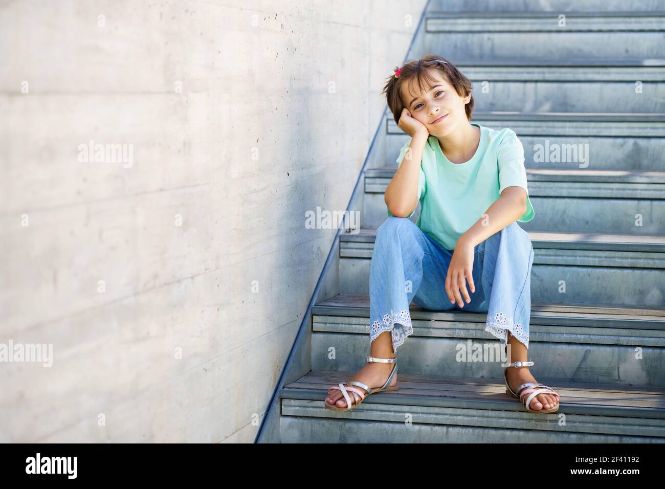 9-jährige Mädchen posiert glücklich auf einer Treppe in der Stadt.. 9-jährige Mädchen posiert glücklich auf einer Treppe Stockfoto