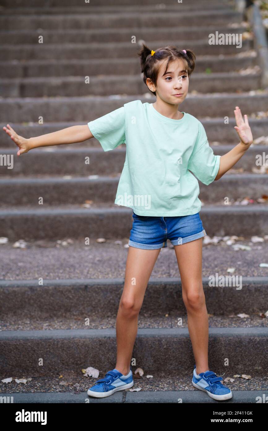 Neunjährige Mädchen tanzen auf den Stufen eines Stadtparks. Neun Jahre altes Mädchen, das auf der Treppe im Freien tanzt Stockfoto