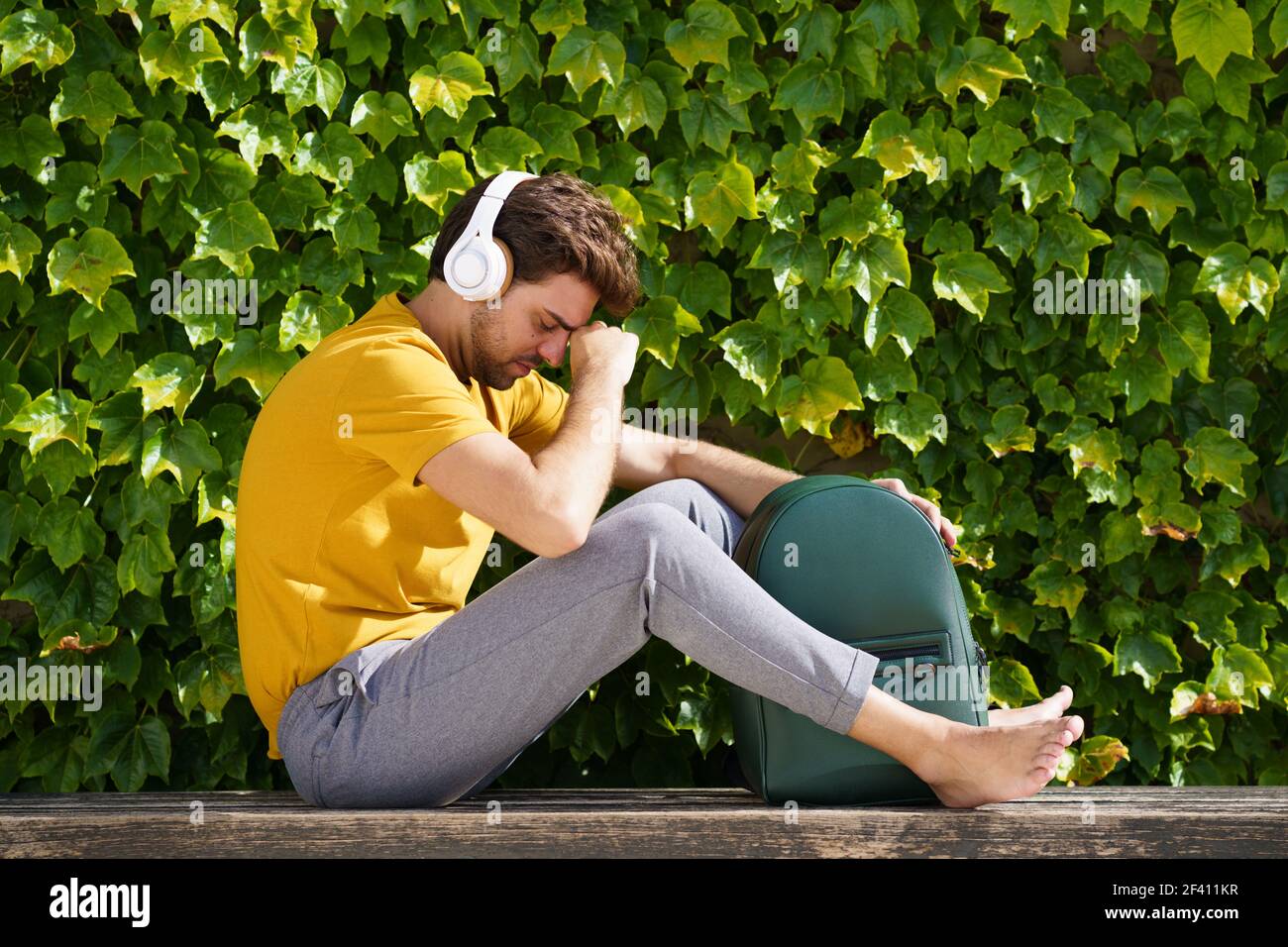Männlich Student sitzt außerhalb besorgt über seine Prüfungen. Junger Student, der draußen saß, machte sich Sorgen um seine Prüfungen Stockfoto