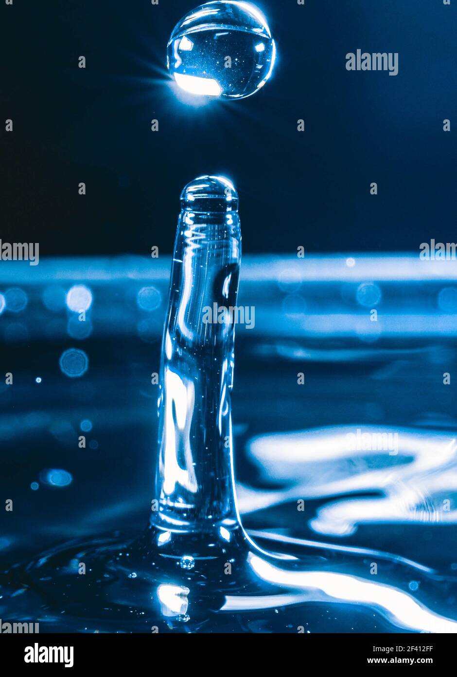 Farbiger Wassertropfen, kreisförmige Wellen, Wasserspritzer, Nahaufnahme. Stockfoto
