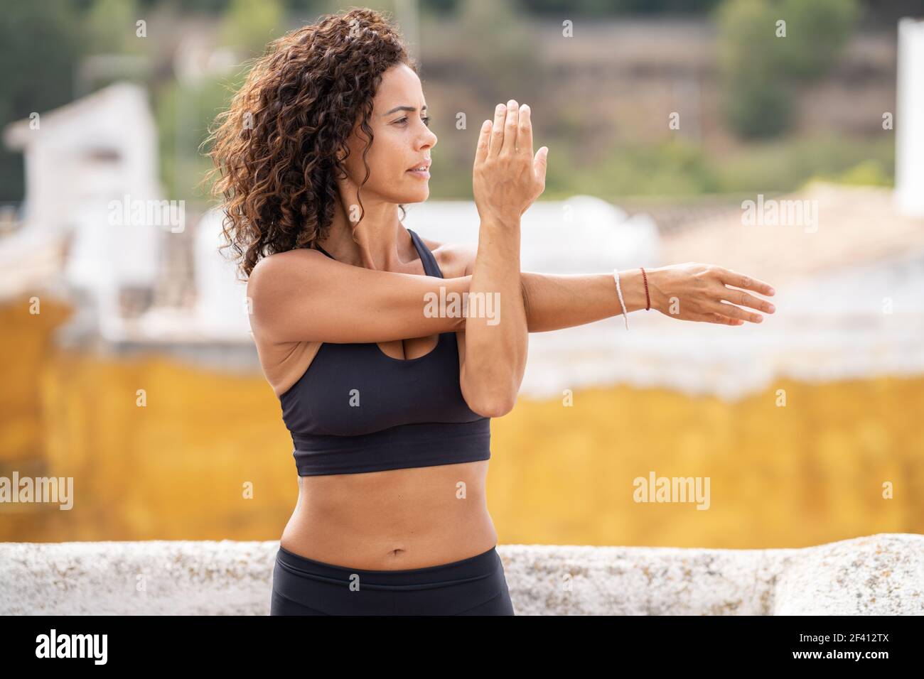 Frau mittleren Alters im Alter von 40s Jahren mit Fitness-Körper trainieren auf der Terrasse ihres Hauses. Frau mittleren Alters mit Fitness-Körper trainieren auf der Terrasse ihres Hauses Stockfoto