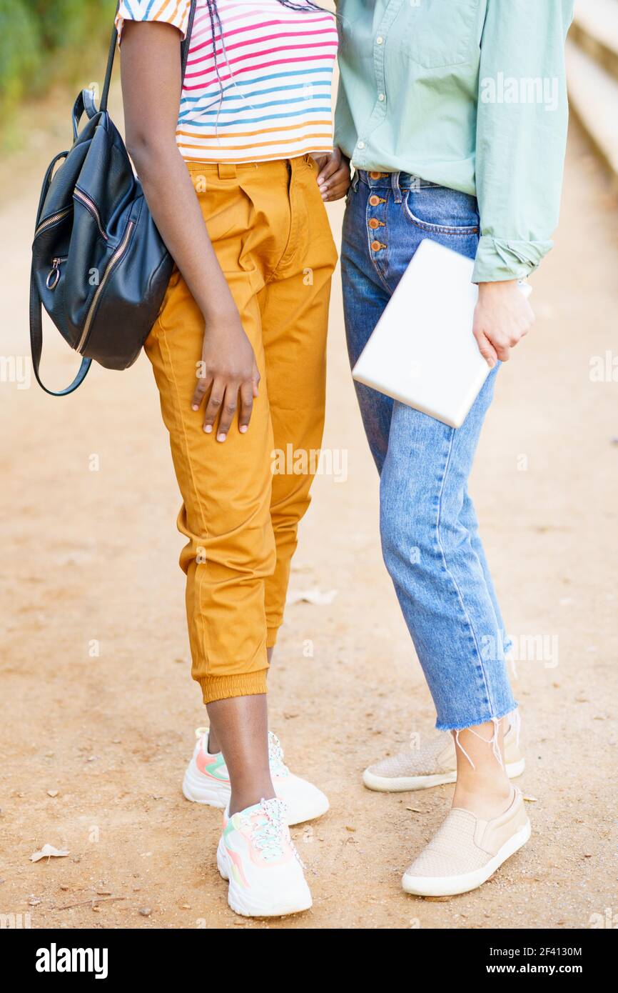 Zwei unkenntlich multiethnischen Mädchen posiert zusammen mit bunten Freizeitkleidung im Freien.. Zwei unkenntlich multiethnische Mädchen posieren zusammen mit bunten Freizeitkleidung Stockfoto