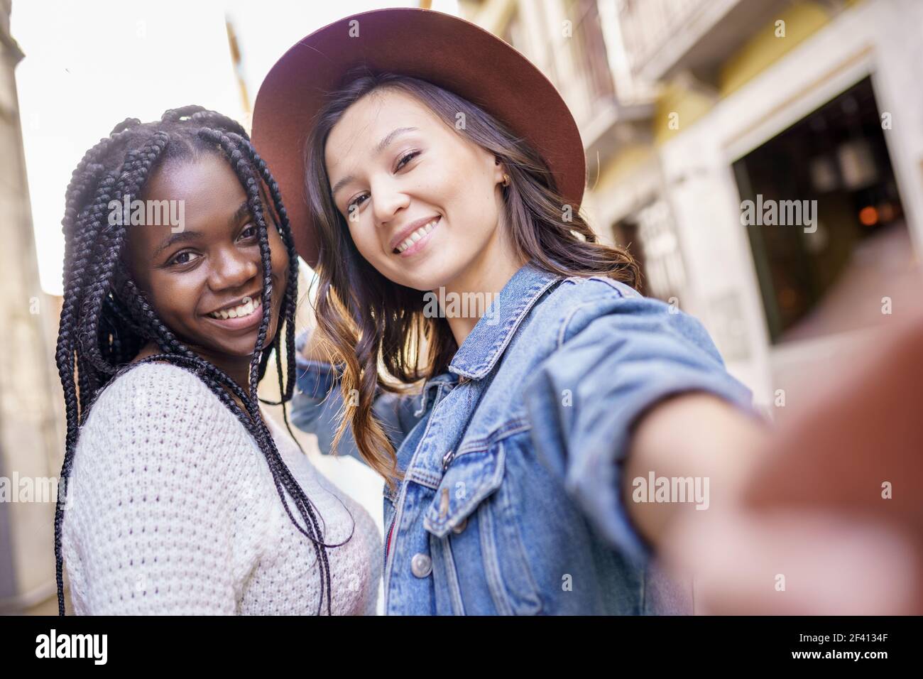 Zwei multiethnische Frauen machen Selfie und Grimacing mit einem Smartphone.. Zwei schöne multiethnische Frauen machen Selfie und Grimacing Stockfoto