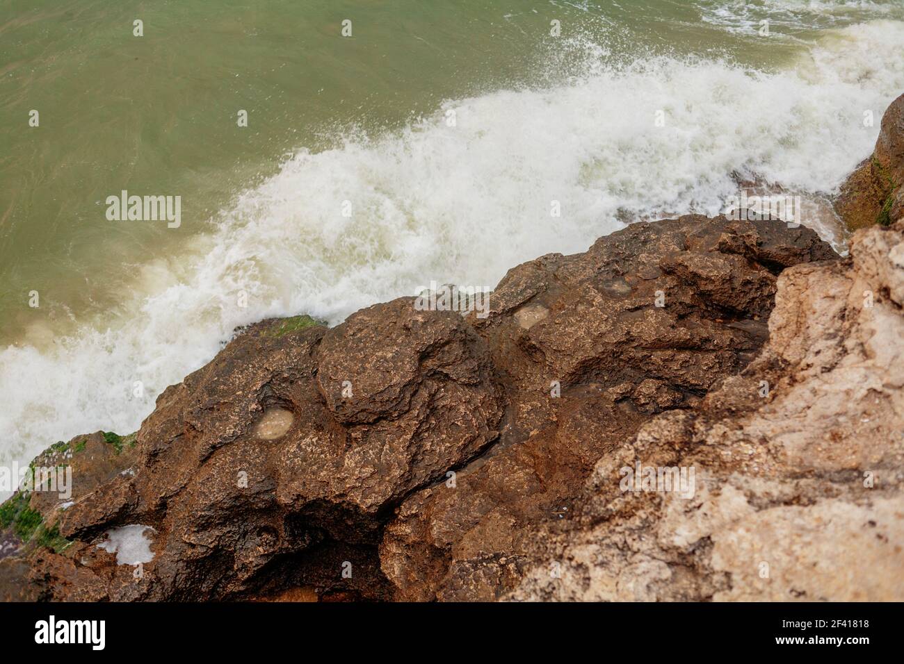 Wellenbrechung über felsige Küste aus der Sicht von oben. Wellenbrecher über felsige Küste Stockfoto