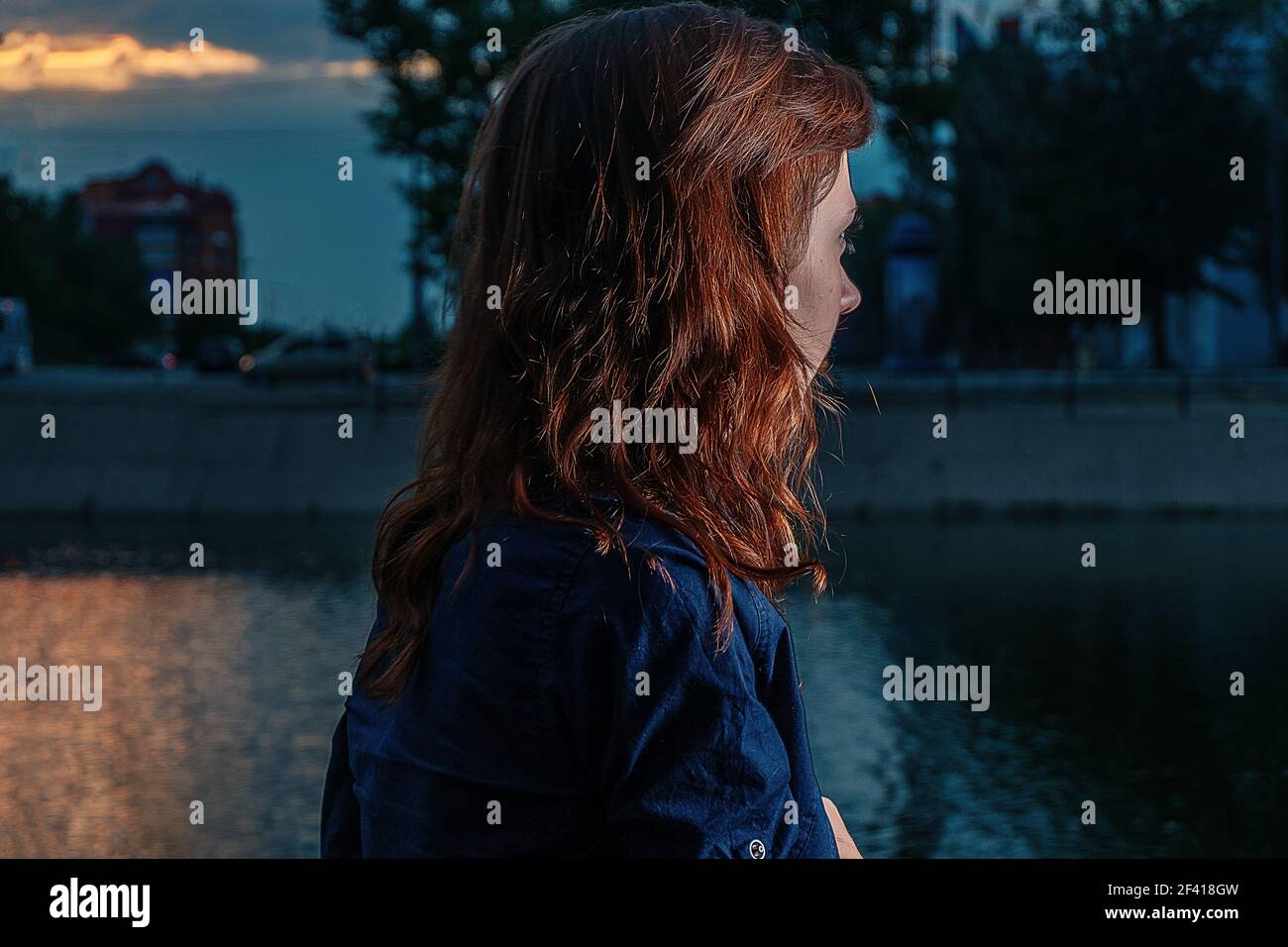 Rothaarige Mädchen Blick auf Nacht Fluss im Stadtpark mit Highlight auf ihre hübschen Ingwer Haar. Einsames Wochenende... Rothaarige Mädchen Blick auf Nacht Fluss im Stadtpark mit Highlight auf ihre hübschen Ingwer Haar. Stockfoto