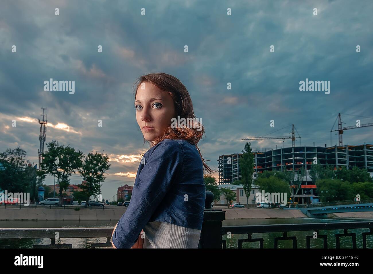 Seriöse Frau blicken unter dramatischem Himmel zurück, Copyspace. Seriöse Frau blicken unter dramatischem Himmel zurück Stockfoto