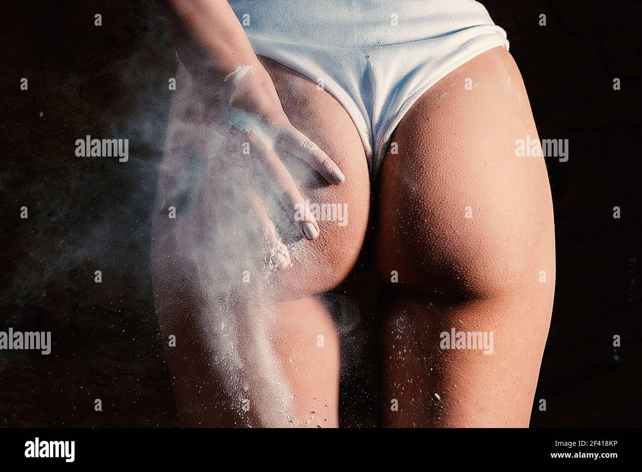 Mädchen spanking sich am Gesäß von ihrer Hand mit feinen weißen Staub. Mädchen spanking sich am Gesäß von ihrer Hand Stockfoto