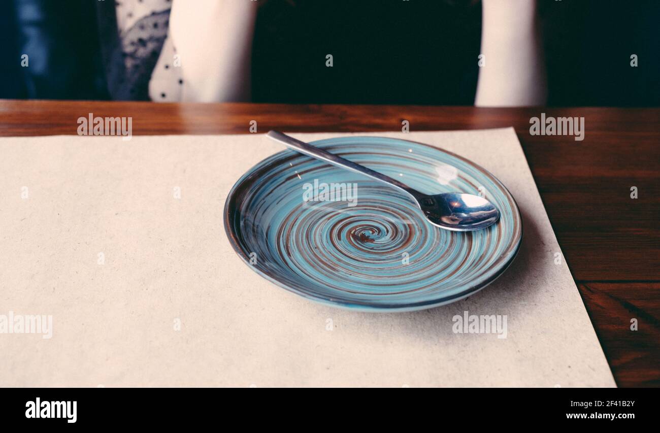 Auf einem Tisch mit Bastelpapier bedeckt gibt es eine Untertasse mit einem Muster von konzentrischen Kreisen.. Auf einem Tisch mit Bastelpapier befindet sich eine Untertasse mit einem Muster konzentrischer Kreise. Stockfoto