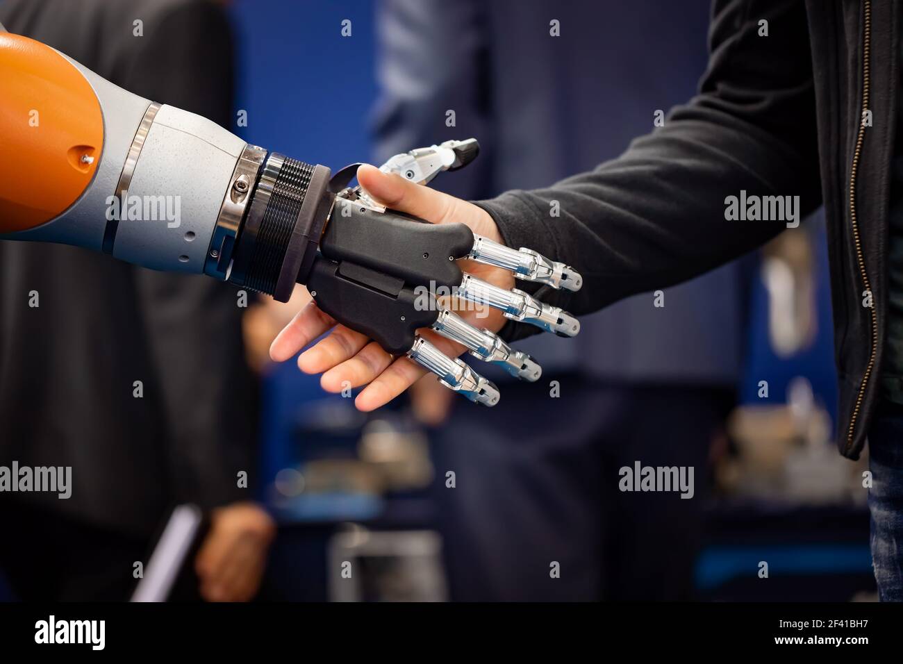 Hand eines Geschäftsmannes Händeschütteln mit einem Android Roboter. Das Konzept der menschlichen Interaktion mit der künstlichen Intelligenz. Stockfoto