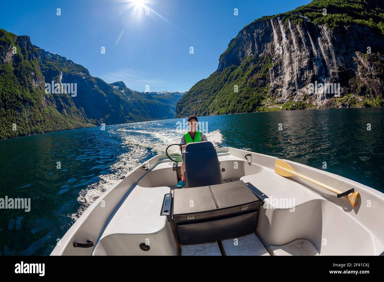 Frau fährt ein Motorboot Seven Sisters Wasserfall auf dem Hintergrund. Geiranger Fjord, schöne Natur Norwegen. Geiranger Fjord, UNESCO-Weltkulturerbe Stockfoto