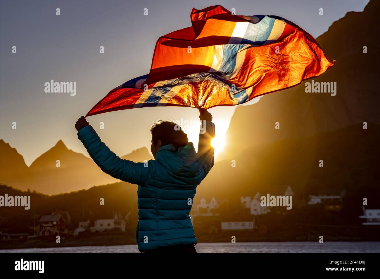 Die Frau winkt die Flagge Norwegens bei Sonnenuntergang Hintergrund Stockfoto