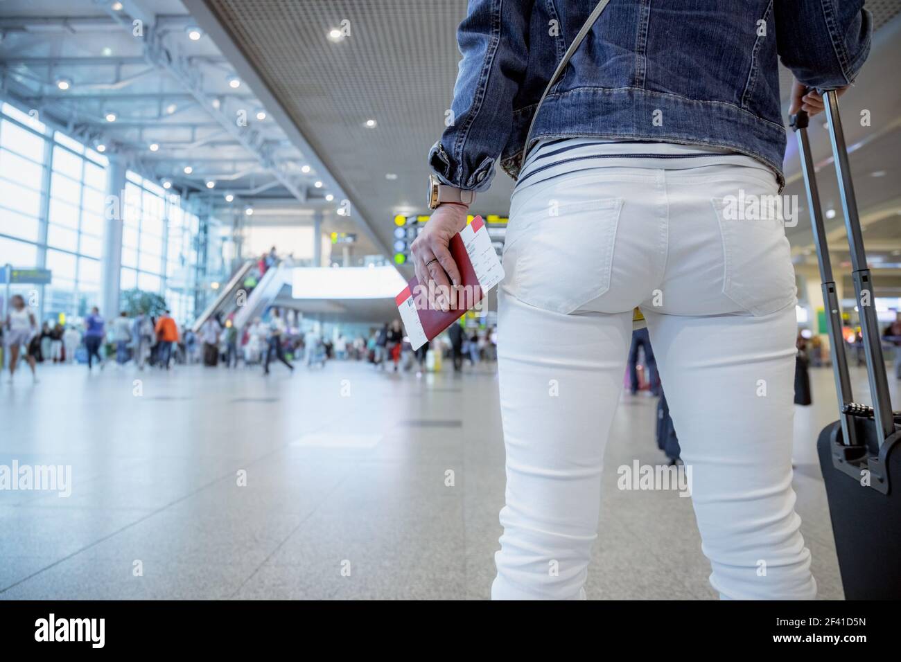 Weibliche Reisende hält einen Reisepass und ein Ticket vor dem Hintergrund der Flughafen Halle Stockfoto