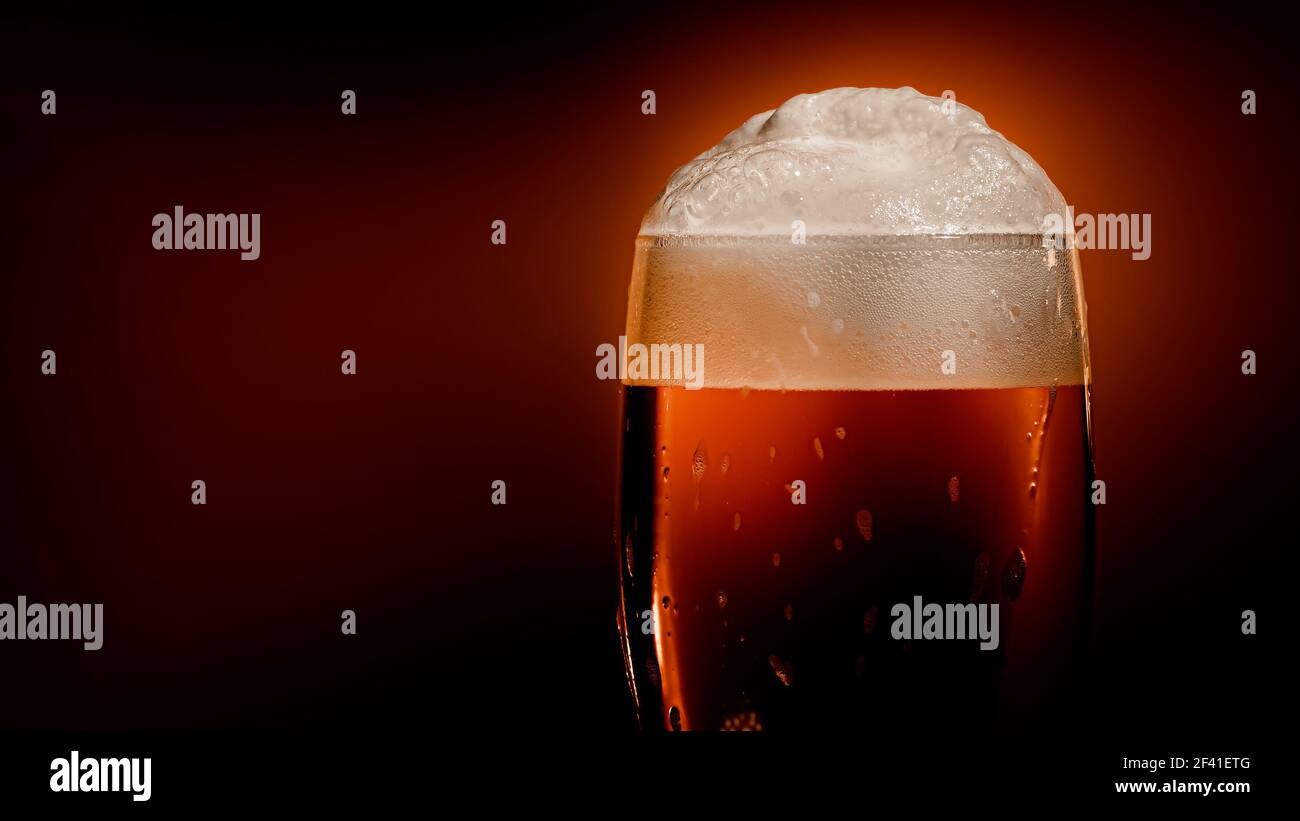 Lagerbier setzt sich im Glas mit einer weißen Schaumkappe ab Stockfoto