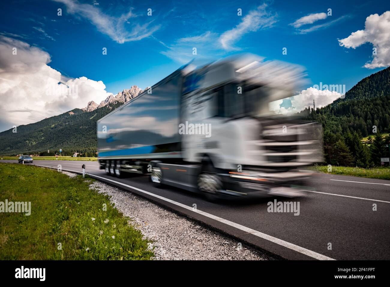 Kraftstoff Lkw Rast auf der Autobahn im Hintergrund die Alpen. Lkw Auto in Bewegungsunschärfe. Stockfoto