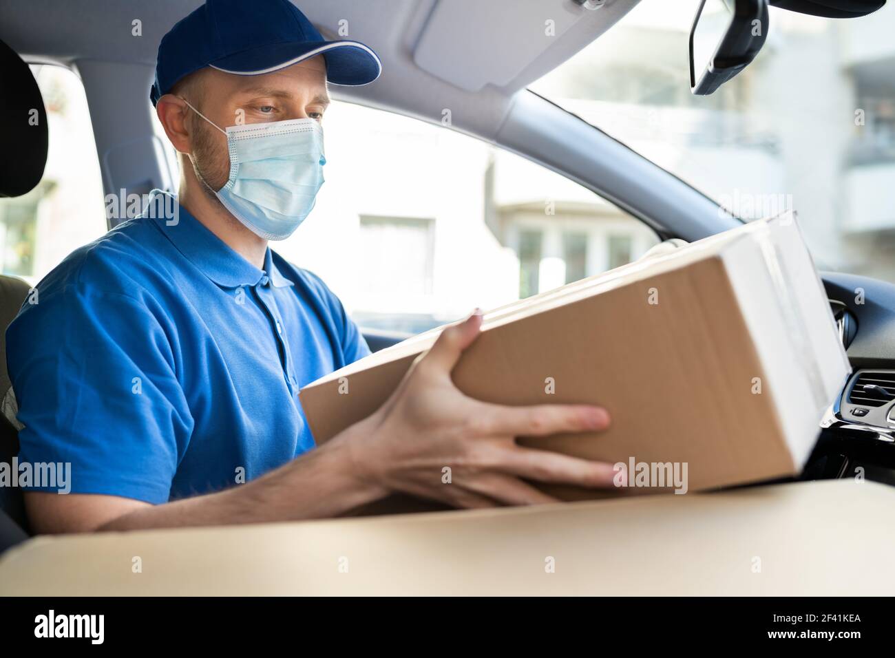 Lieferung Arbeiter Mann In Medizinischen Gesichtsmaske Im Auto Stockfoto