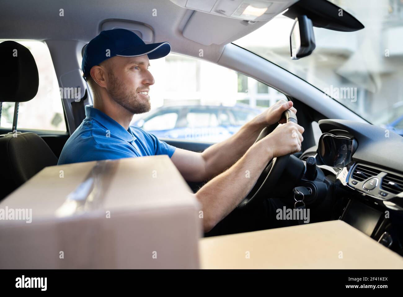 Delivery Worker Man In Uniform Im Auto Stockfoto