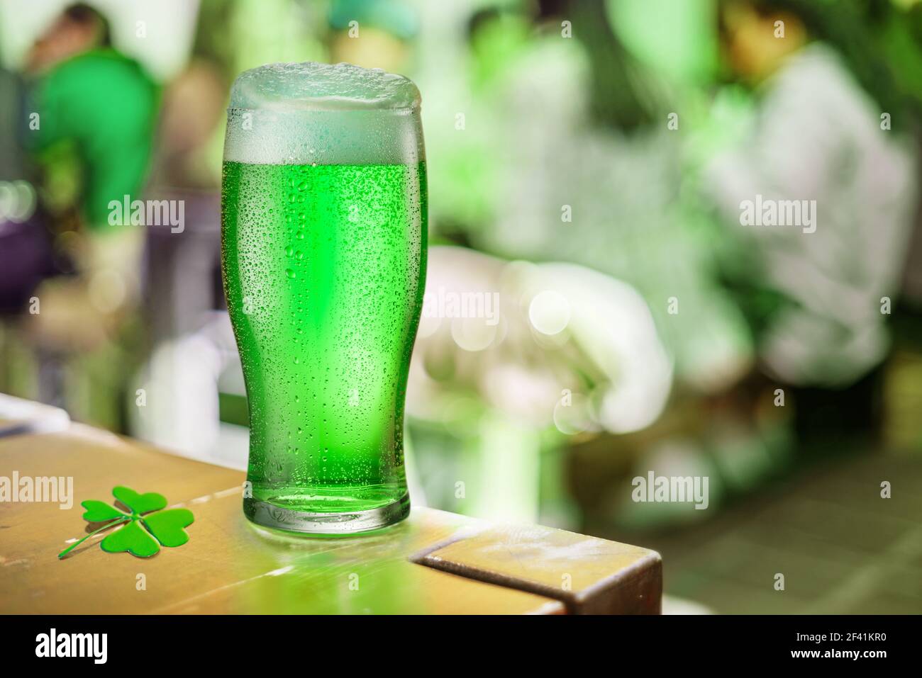 Bei der Feier des St. Patrick's Day steht in einem Pub ein Glas Grünbier auf dem Tisch. Grünes Bier - ein Symbol für das fest des Heiligen Patrick Tages. Stockfoto