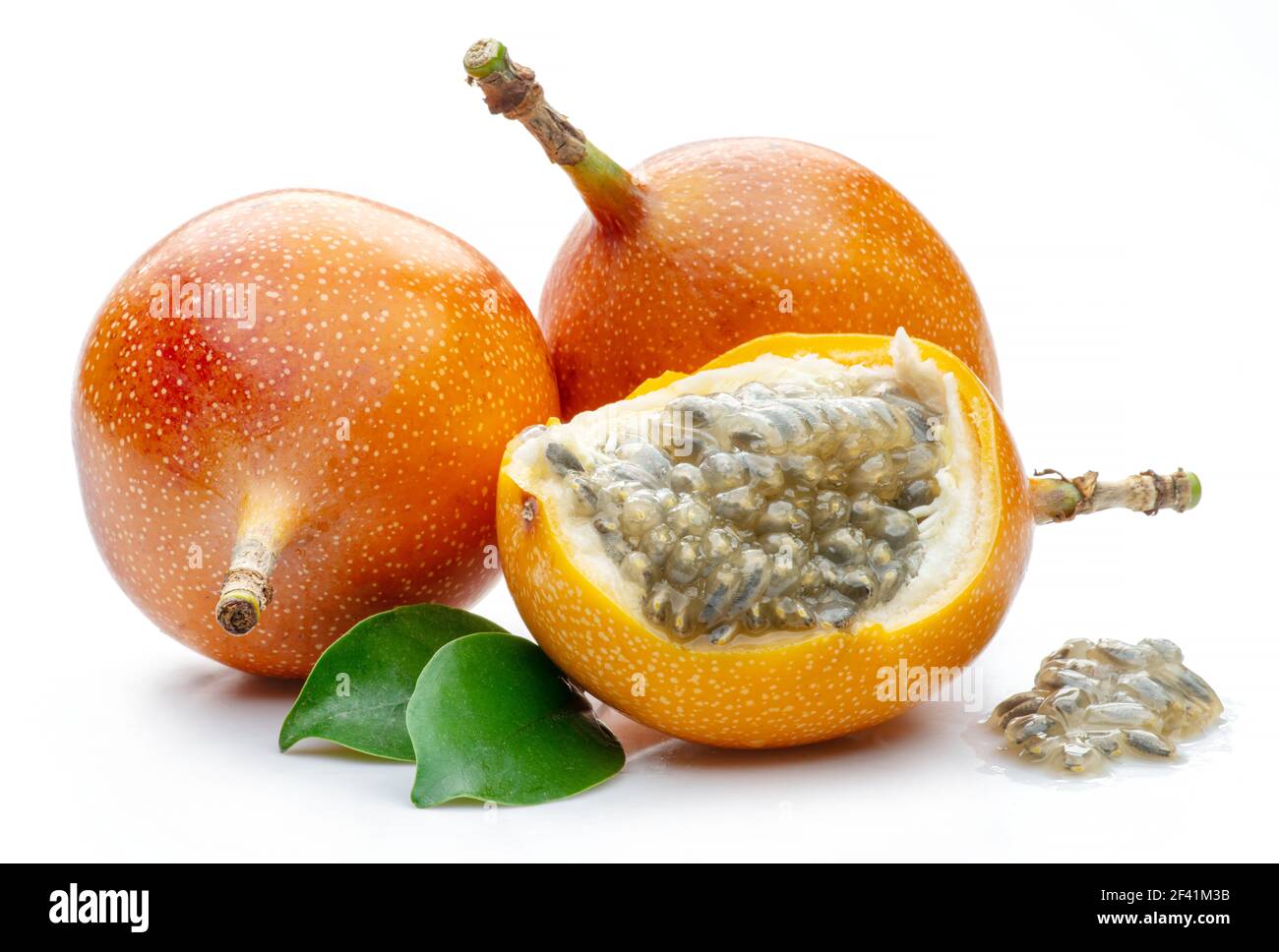 Granadilla mit Blättern und Passionsfrucht halb isoliert auf weißem Hintergrund. Stockfoto