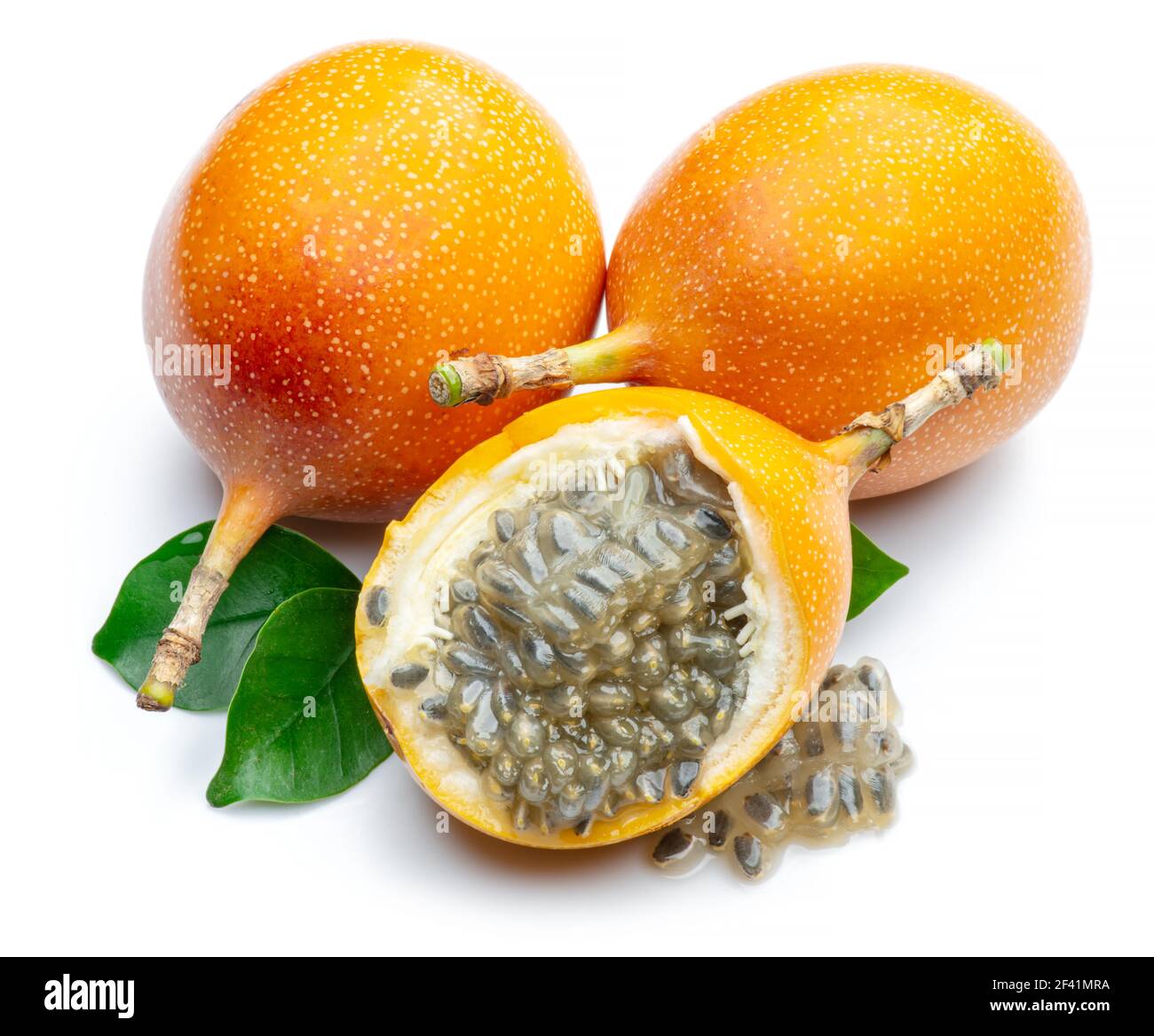 Granadilla mit Blättern und Passionsfrucht halb isoliert auf weißem Hintergrund. Stockfoto