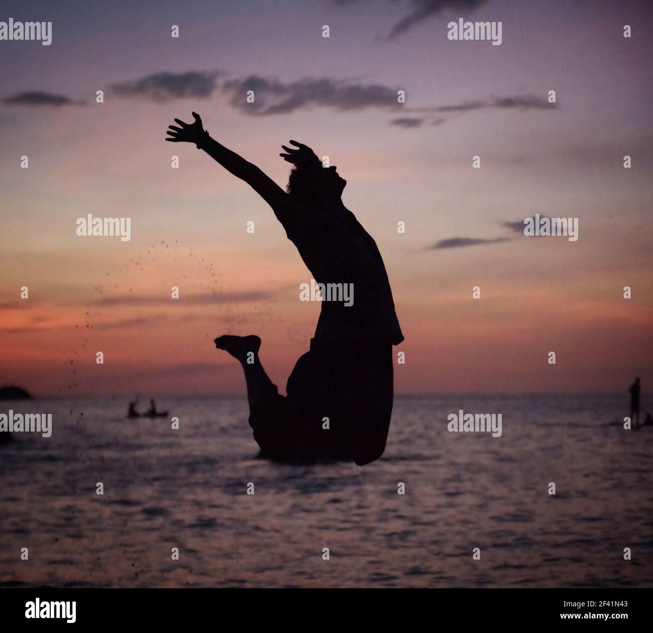 Silhouette eines entspannten, jungen Mannes springen am Strand Stockfoto