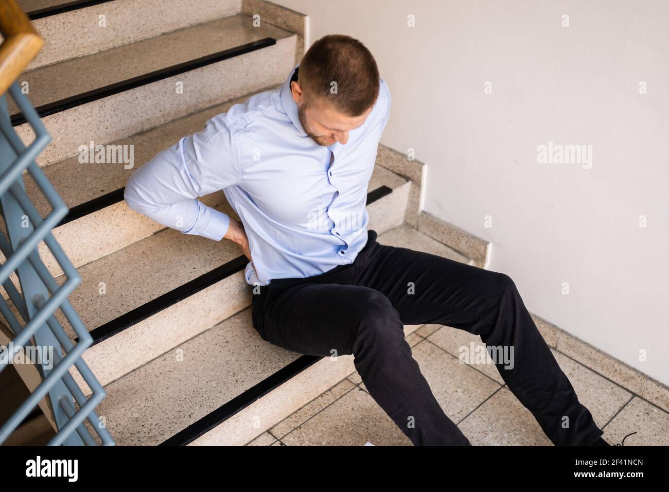 Unfall Mit Fall- Und Fallverletzung Am Arbeitsplatz. Mann Fiel Die Treppe Hinunter Stockfoto