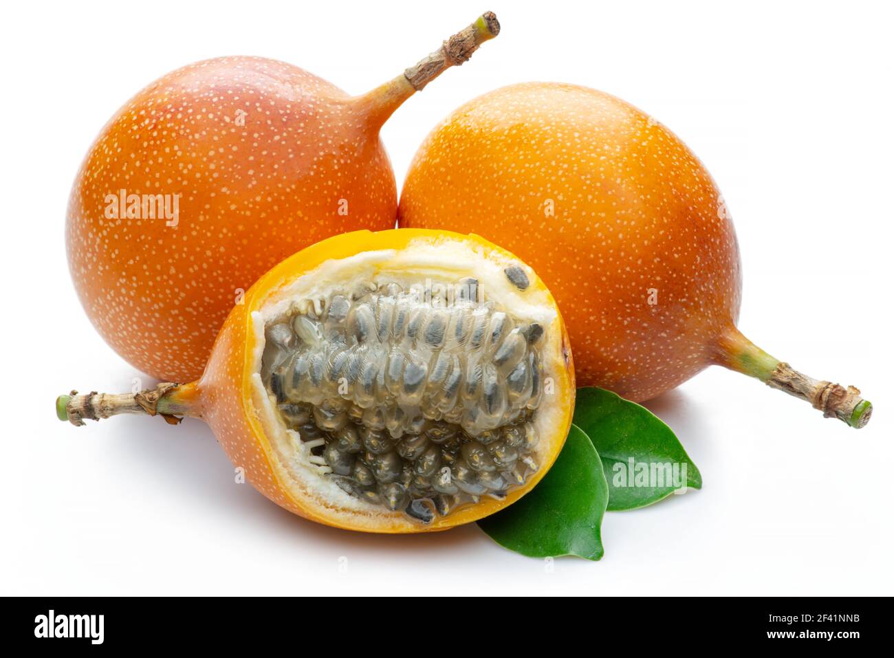 Granadilla mit Blättern und Passionsfrucht halb isoliert auf weißem Hintergrund. Stockfoto