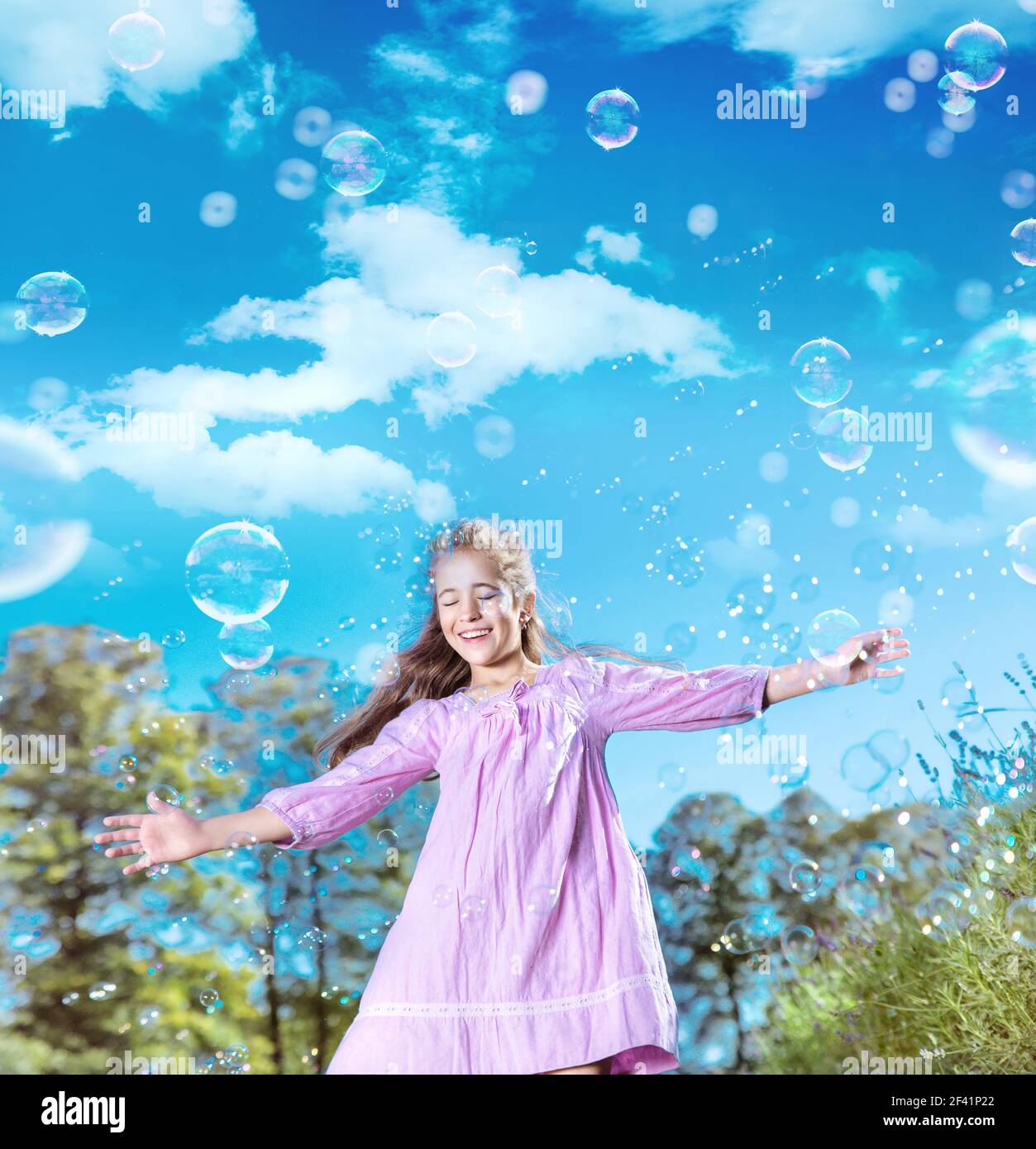 Portrait eines hübschen jungen Mädchen tanzen zwischen vielen Seifenblasen Stockfoto