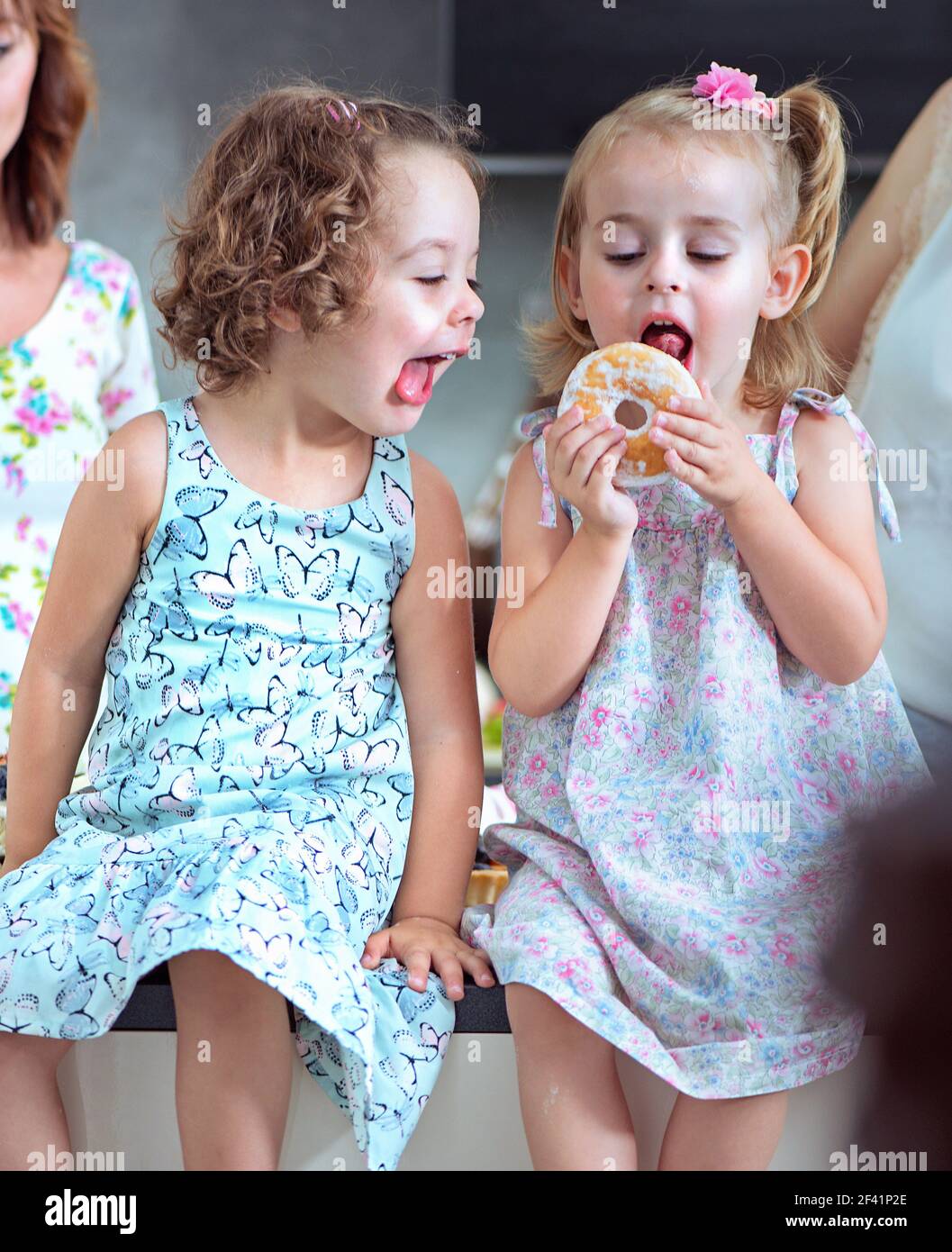 Süße Kinder essen süße, bunte Donuts Stockfoto