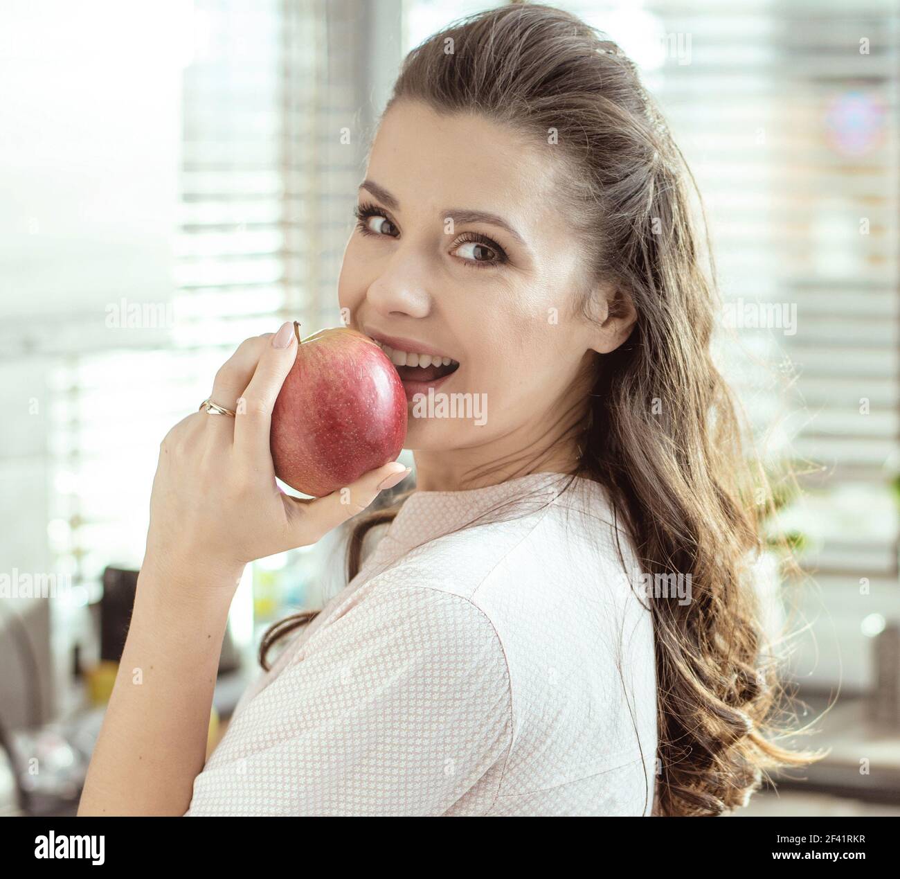 Porträt einer hübschen Dame einen frischen Apfel beißen Stockfoto
