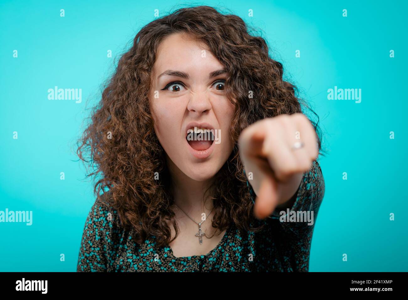 Verärgerte Frau schimpft jemanden und zeigt mit dem Finger auf Die Kamera Stockfoto