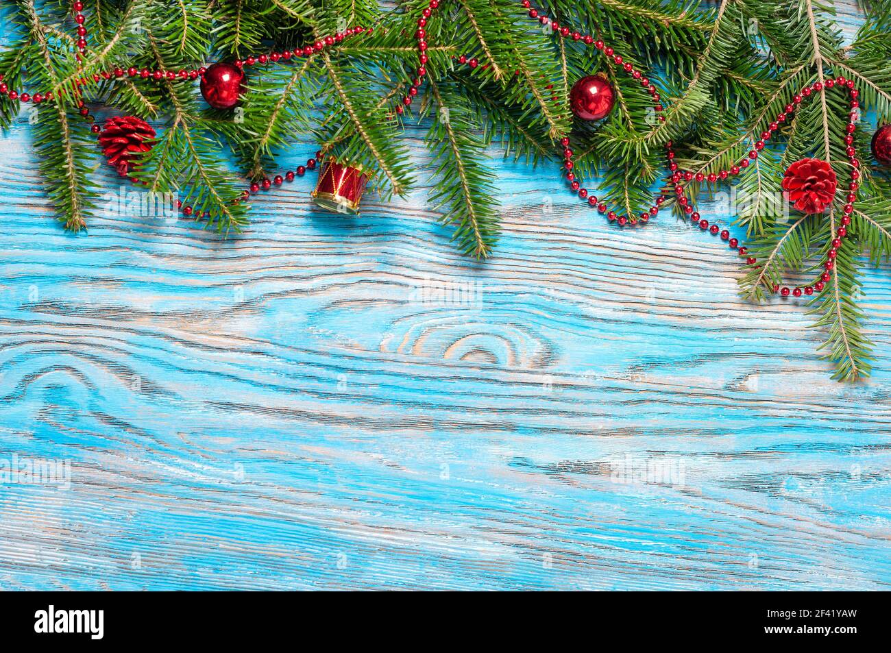 Red Weihnachtsschmuck und Tanne Zweig auf blauem Untergrund aus Holz Stockfoto