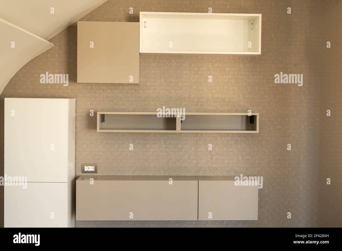 Hängende Schränke und Regale im Inneren eines Wohnhauses in verschiedenen Grautönen. Stockfoto