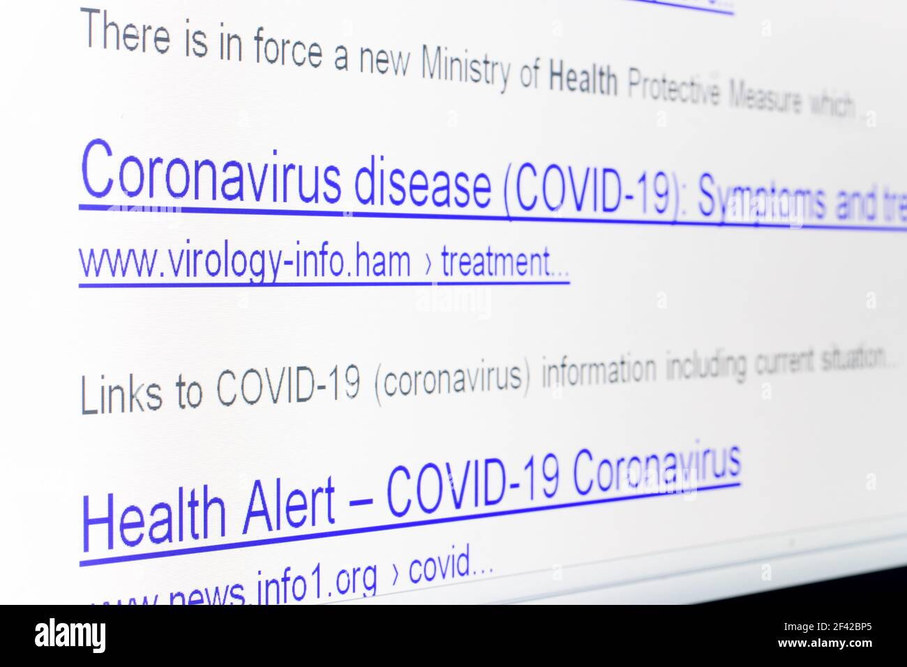Internet-Suchergebnisse für Coronavirus mit den Links von imaginären nicht vorhandenen Websites auf dem Display, close up. Stockfoto