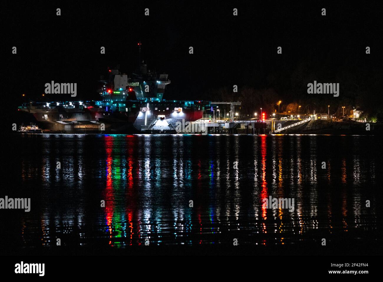 Finnart, Loch Long, Schottland, Großbritannien. März 2021, 18th. IM BILD: HMS Queen Elizabeth um nigh9t mit Reflexionen auf dem Wasser von Loch Long. HMS Queen Elizabeth ist das größte und fortschrittlichste Kriegsschiff, das jemals für die Royal Navy gebaut wurde. Die Aircraft Carrier liegt derzeit an der Seite des Long Loch in Glenmallan und übernimmt Treibstoff, Munition und andere Vorräte, bevor die Marineübungen, die Teil der britischen Carrier Strike Group 2021 sind, durchgeführt werden. Das Schiff soll am Sonntag abreisen. Quelle: Colin Fisher/Alamy Live News Stockfoto