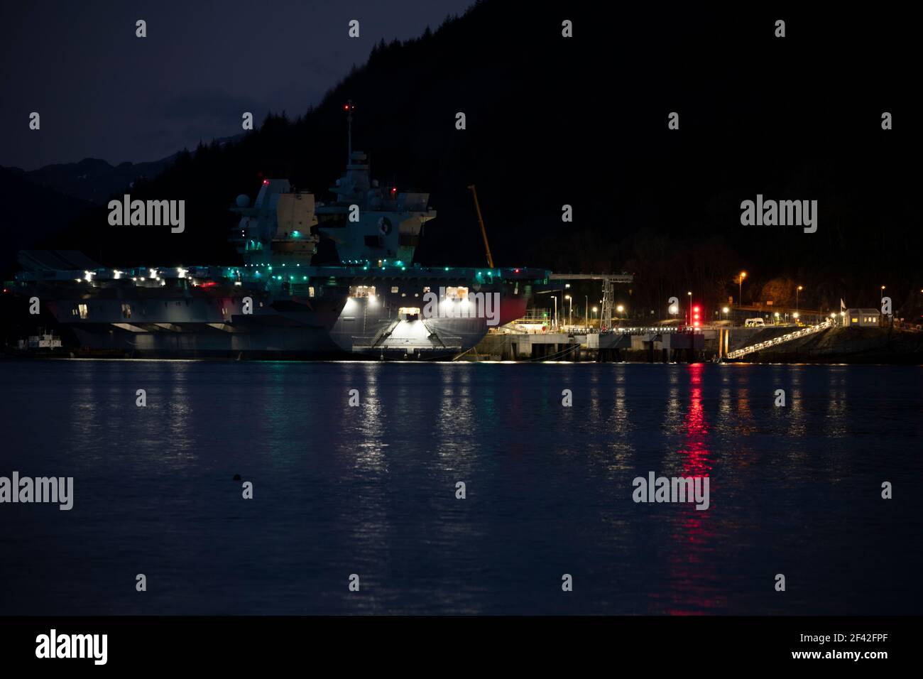 Finnart, Loch Long, Schottland, Großbritannien. März 2021, 18th. IM BILD: HMS Queen Elizabeth um nigh9t mit Reflexionen auf dem Wasser von Loch Long. HMS Queen Elizabeth ist das größte und fortschrittlichste Kriegsschiff, das jemals für die Royal Navy gebaut wurde. Die Aircraft Carrier liegt derzeit an der Seite des Long Loch in Glenmallan und übernimmt Treibstoff, Munition und andere Vorräte, bevor die Marineübungen, die Teil der britischen Carrier Strike Group 2021 sind, durchgeführt werden. Das Schiff soll am Sonntag abreisen. Quelle: Colin Fisher/Alamy Live News Stockfoto