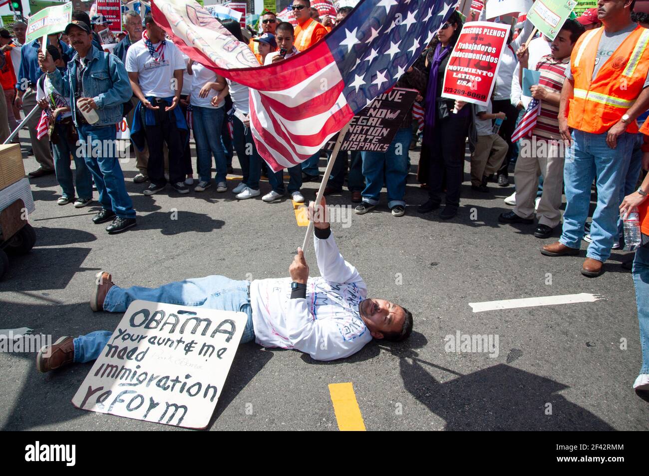 Ein Protestler schwenkt eine Flagge, während er ein Schild zeigt, das Präsident Obama während eines Immigrationsrechtsprotest in Downtown Los Angeles im Jahr 2009 appelliert. Stockfoto