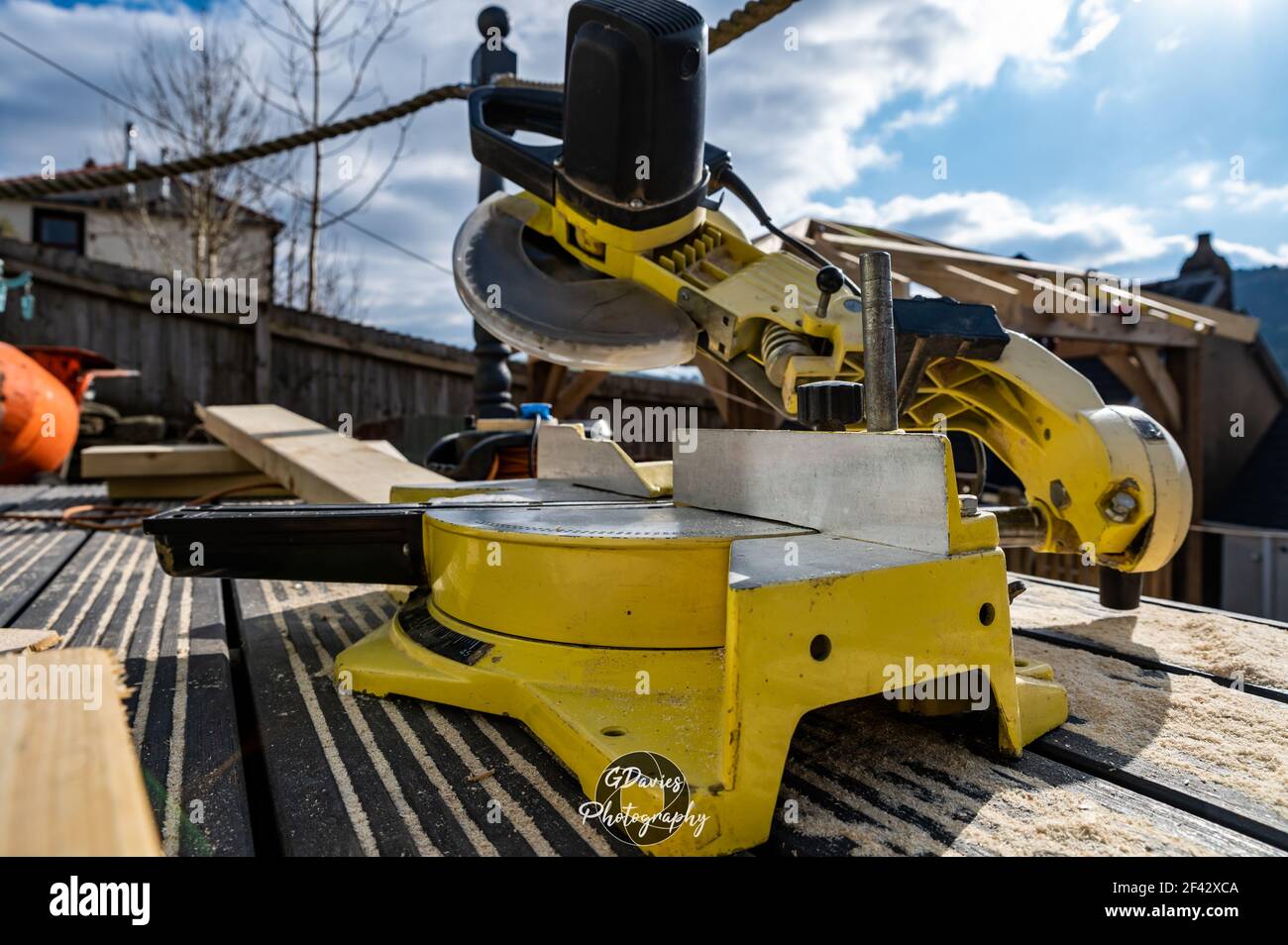 Nahaufnahme der gelben Säge saß auf hölzernen Deck Wesen Verwendet, um hölzerne Pavillon Dach zu bauen Stockfoto