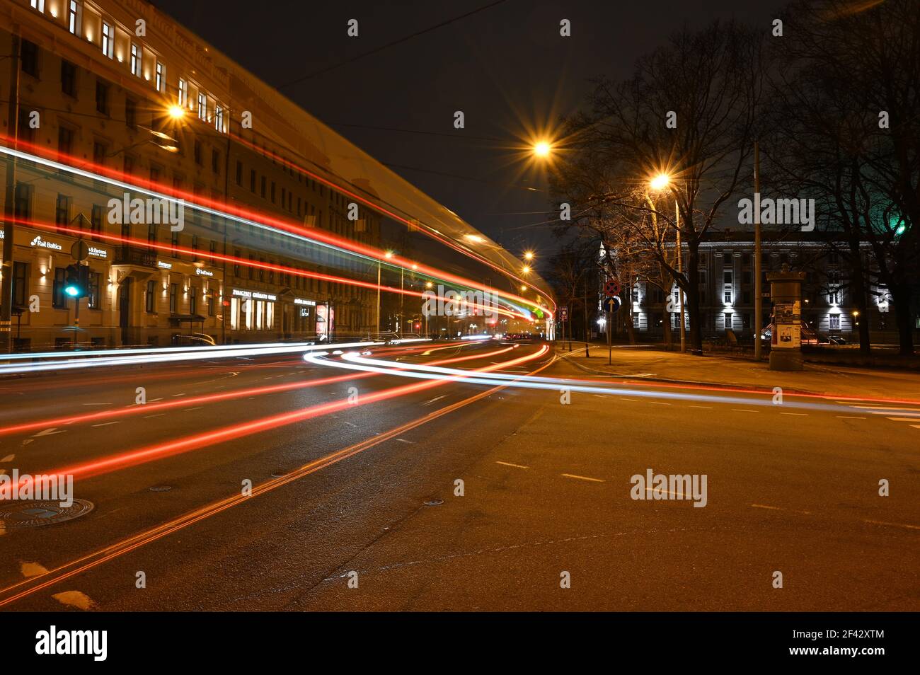 Farbenfrohe, lichtdurchflute Wege in der Stadt bei Nacht, die hoch von der Straße geht, wenn der Bus vorbeifährt. Stockfoto