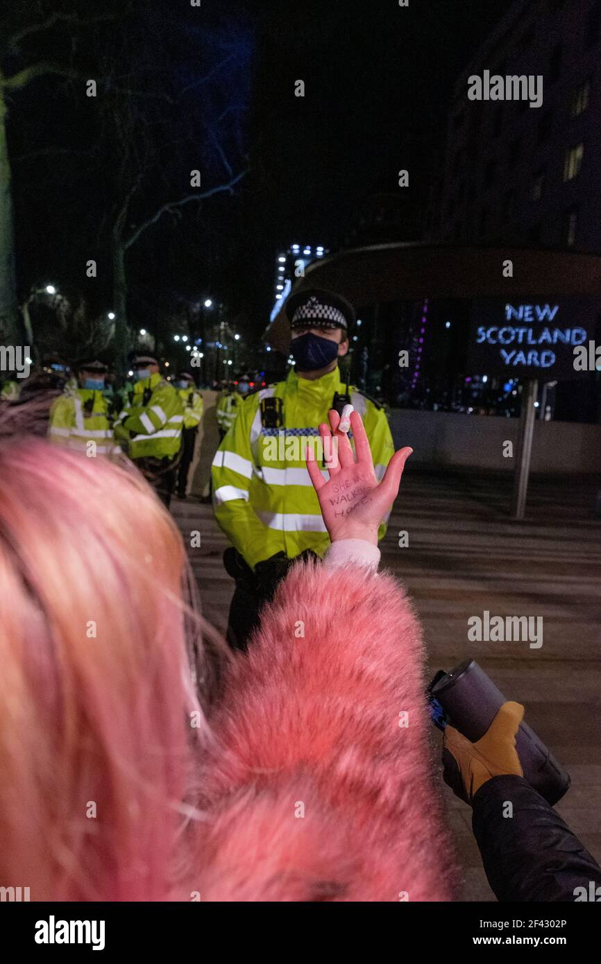 London, Großbritannien. März 2021, 16th. Frau hält einen Tampon vor dem New Scotland Yard. "Sie ging gerade nach Hause", schrieb sie in ihre Hand. Tausende versammelten sich auf dem Parliament Square, um das Bewusstsein für die Sicherheit von Frauen zu schärfen und gegen das PCSC-Gesetz zu protestieren. Die Polizei im Zentrum Londons nahm am Montagabend Verhaftungen vor, als Tausende von Menschen sich versammelten, um gegen die Verabschiedung eines neuen Polizeigesetzes zu protestieren und Gewalt gegen Frauen hervorzuheben. Die Gesetzesvorlage für Polizei, Kriminalität, Verurteilung und Gerichte wurde von zivilgesellschaftlichen Gruppen als Angriff auf einige der grundlegendsten Rechte der Bürger kritisiert. Proteste um Stockfoto