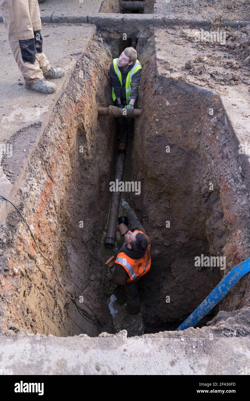 Bauherren in hohen viz graben die Straße, tiefes Loch, um Abwasserleitung unterirdisch für Wohnhaus, London zu installieren Stockfoto