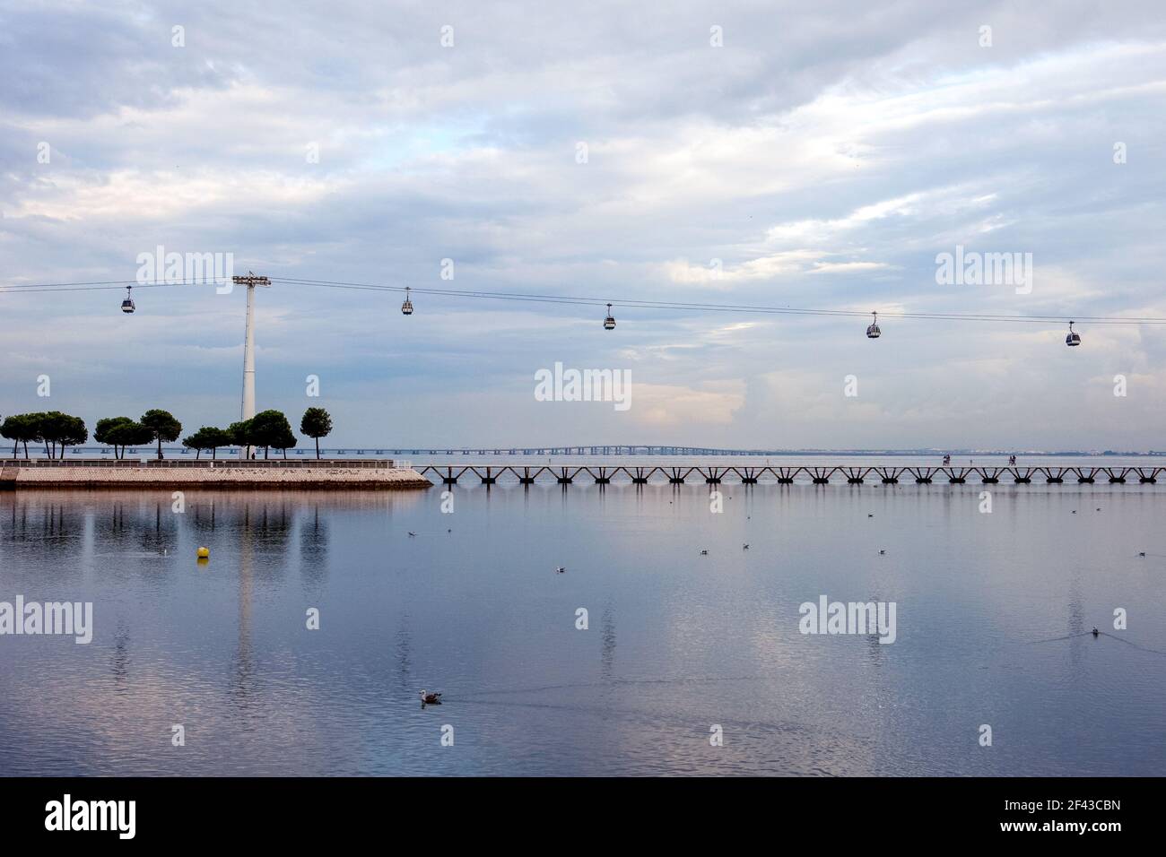 Die Seilbahnen, die über den Tejo Fluss im Parque das Naçoes in Expo fliegen, mit der Vasco de Gama Brücke im Hintergrund - Lissabon, Portugal Stockfoto