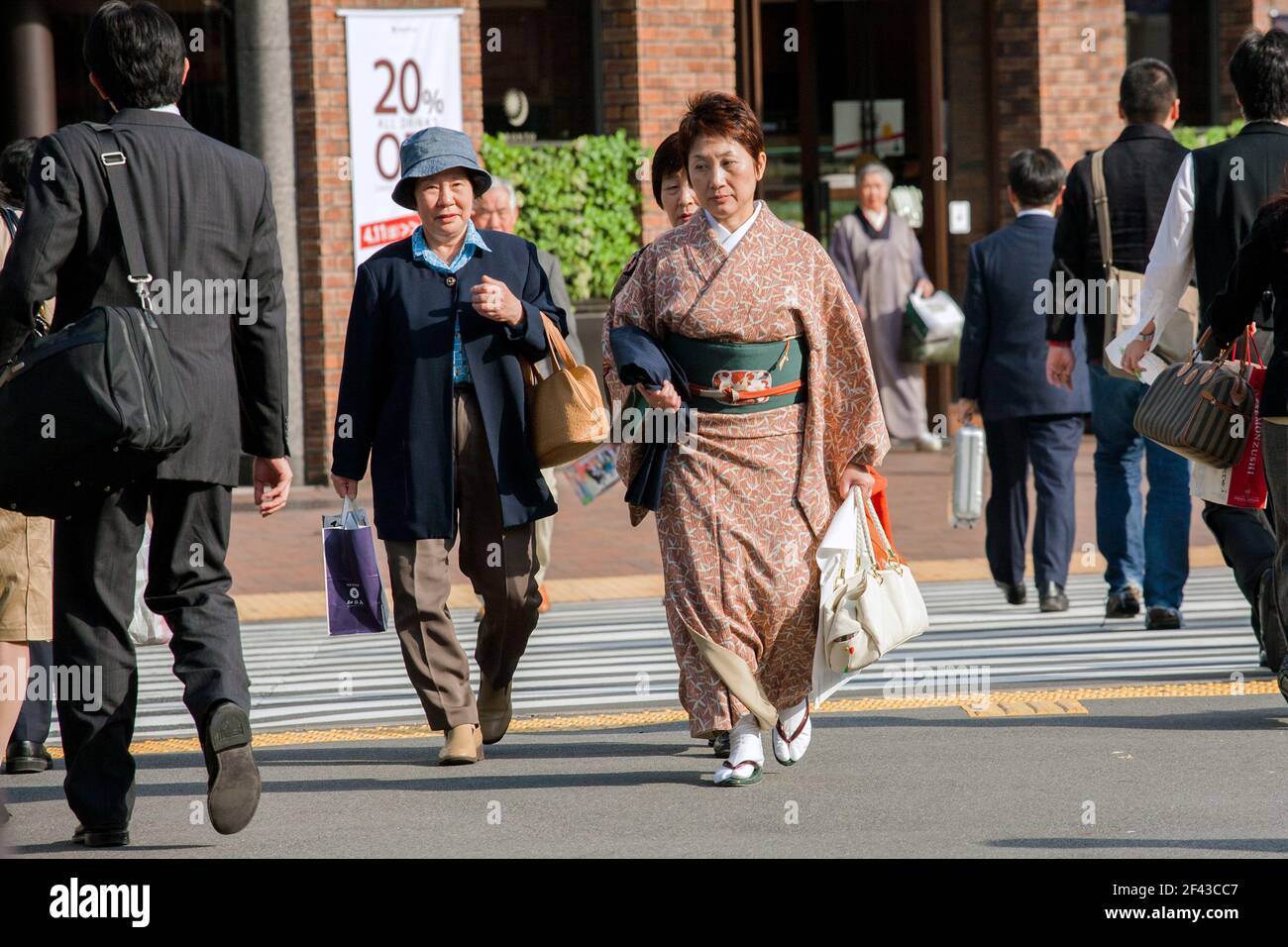 Japanische Frau mittleren Alters, die Kimono trägt, läuft im Ginza-Einkaufsviertel, Tokio, Japan Stockfoto