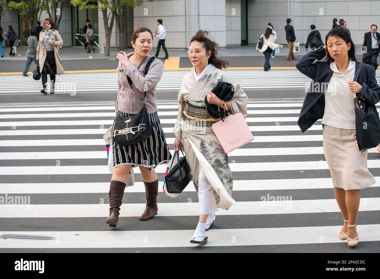 Weibliche Japanerin mittleren Alters, die Kimono trägt, geht über die Fußgängerzebra-Kreuzung, Tokio, Japan Stockfoto