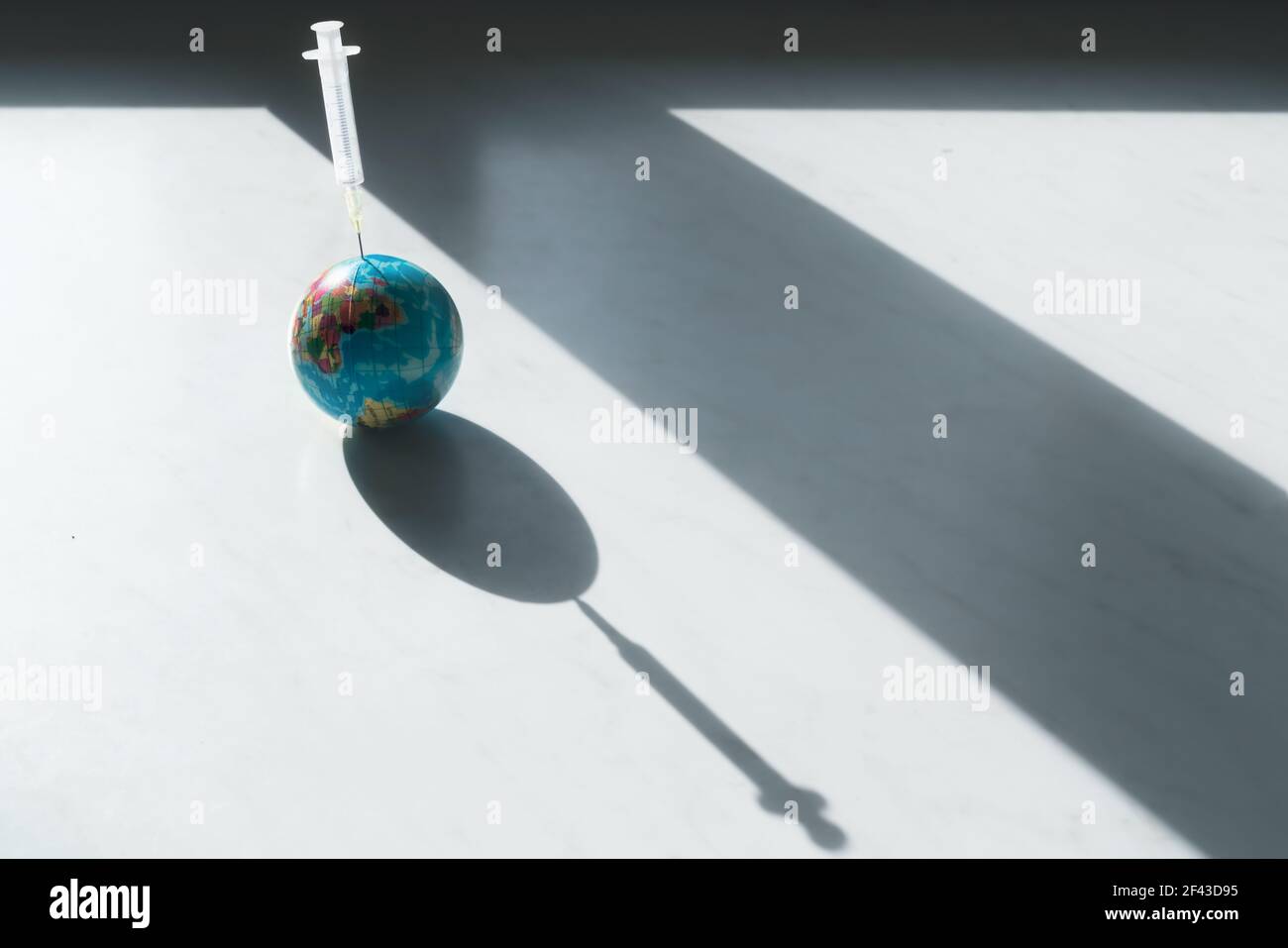 Pessimistisches Symbol für die globale Impfung und Immunisierung gegen covid-19 on Die Erde mit Spritze im Planeten Stockfoto