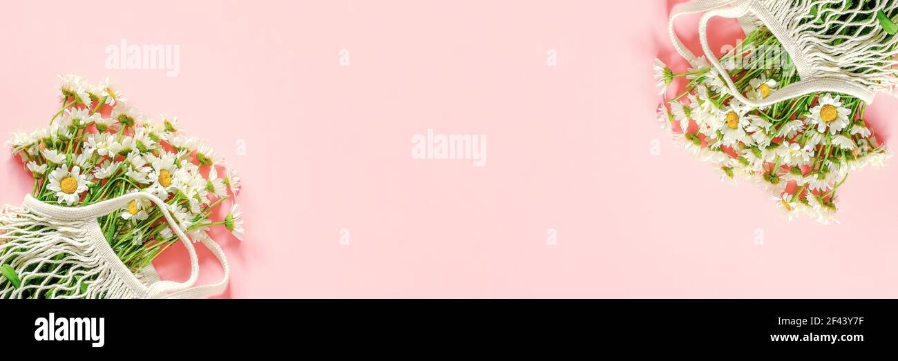 Bouquet von Feldblumensträuße in wiederverwendbaren Shopping Öko Netzbeutel auf rosa Hintergrund. Konzept kein Kunststoff und kein Abfall. Kopierbereich – Banner in der Draufsicht. Stockfoto