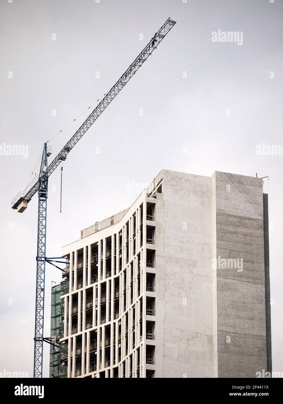 Bild mit geringer Sättigung eines unfertigen Gebäudes und eines Hubkrans. Stockfoto