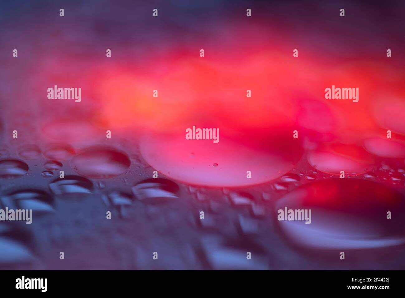 Nasser, dunkel leuchtender abstrakter Hintergrund. Blaue, violette und Feuerfarben. Makro Stockfoto