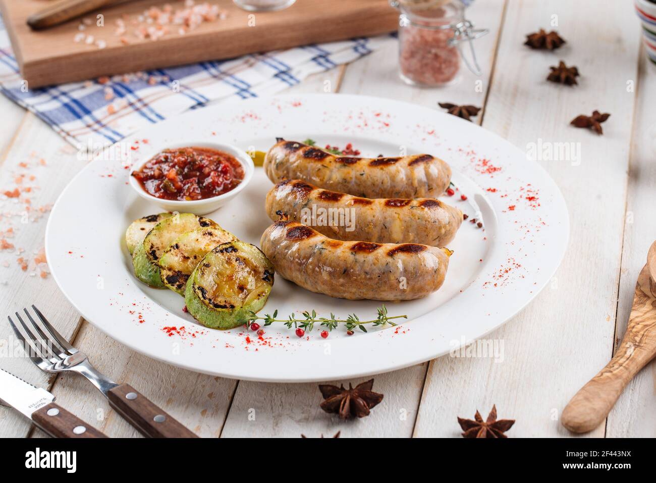 Gegrillte Würstchen mit Squash und heißer Sauce Stockfoto