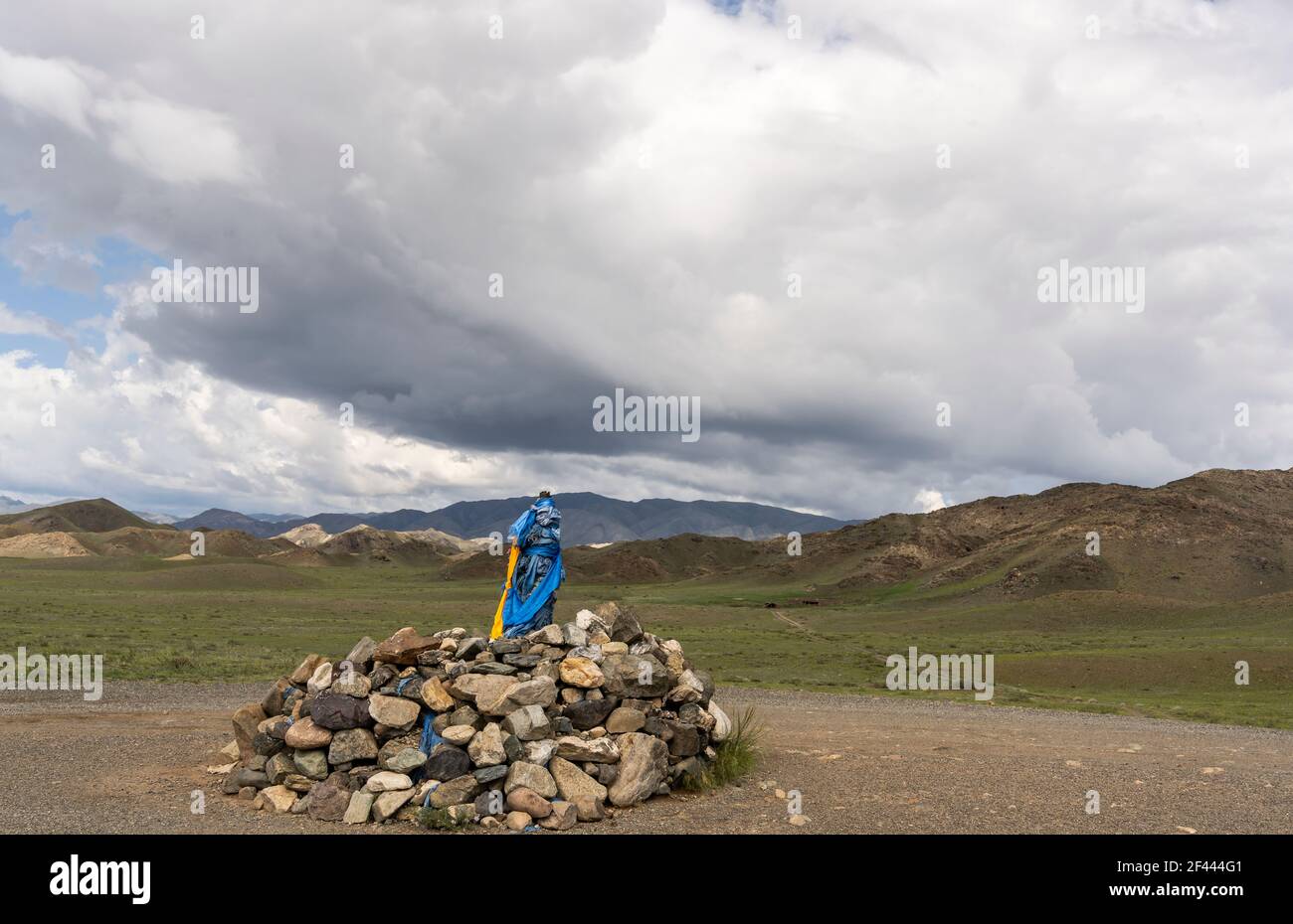 Ovoo mit blauen und orangen Fahnen in der Mongolei, ein heiliger Ort im Buddhismus auf einem Berg in der Mongolei. Stockfoto